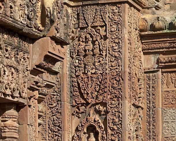 sm_banteisreigN1411 Male temple guardian with hair being swept up in a cylindrical chignon, corner of the central tower, Banteay Srei temple, Citadel of the Women, Angkor, Cambodia