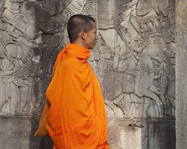 sm_bayonN1434 Buddhist monk in front of a bas-relief in the outer gallery, Bayon temple, Angkor Thom, Siem Reap, Cambodia