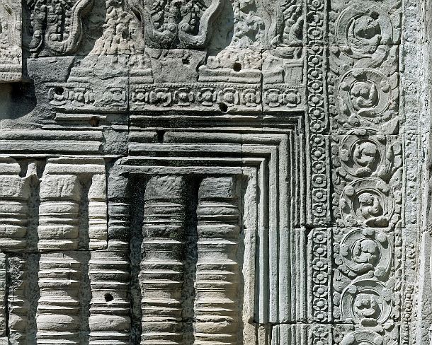 smpreakhanN1463 Wall decorated with intricate sand stone carvings and a false window (baluster), Preah Khan temple, built by King Jayavarman VII in 12th century, Angkor,...