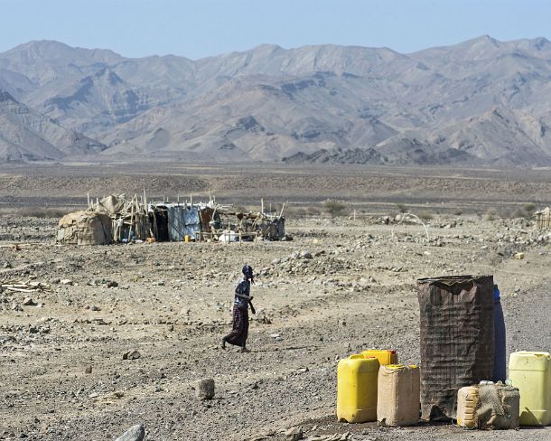 sm1gva_ET_cx3415_g Afar man collecting the filled water jerry cans distributed at the road side, Danakil depression, Afar Triangle, Ethiopia