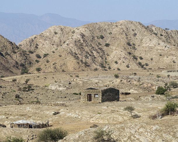 sm1gva_ET_cx4135_g Simple stone-built house in front of the arid Atsbi mountain chain, Afar Triangle, Ethiopia