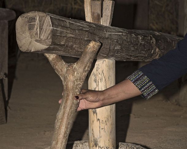 smLuangPN1543 Husking rice grains with a piece of timber that hammers the rice in a stone bowl, traditional rice harvest, Living Land Rice Farrm in Ban Phong Van close to...